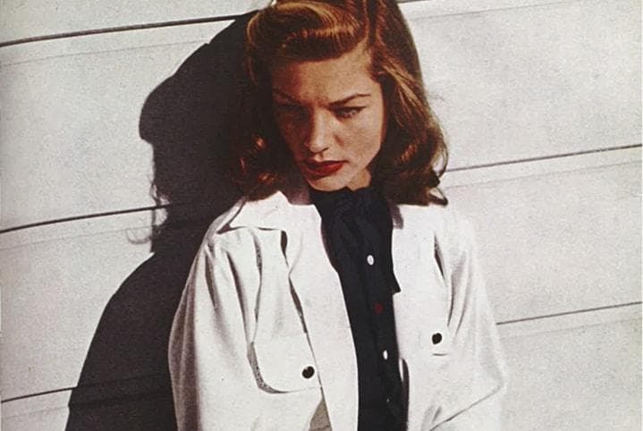 Lauren Bacall in classic 1940s Hollywood film still, showcasing signature bold brows, luminous skin and red lipstick