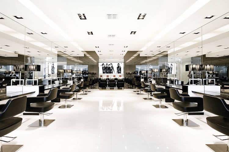 Modern salon interior with black leather chairs, chrome finishes and mirrored walls at Wieselmann in South Yarra