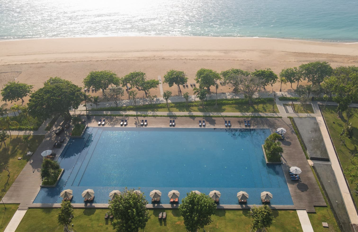 Aerial view of Sanur's coastline and lush tropical gardens surrounding Bali Beach Hotel and The Meru Sanur resort complex