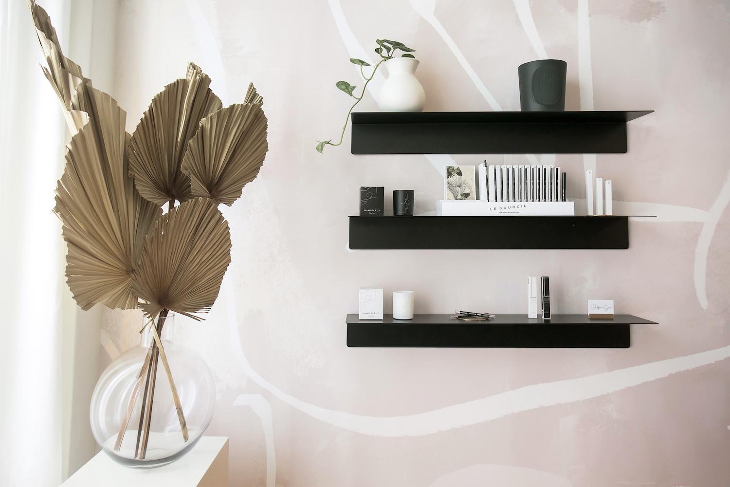 Delphine Sorel salon interior with beige and grey palette, half-moon mirror, and preserved floral arrangements