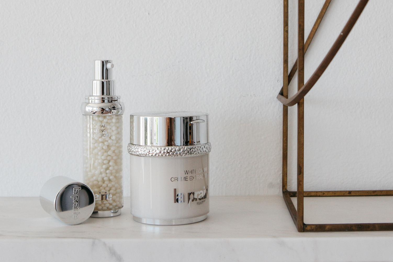 Luxury winter skincare products arranged on marble surface with pearl and gold textures
