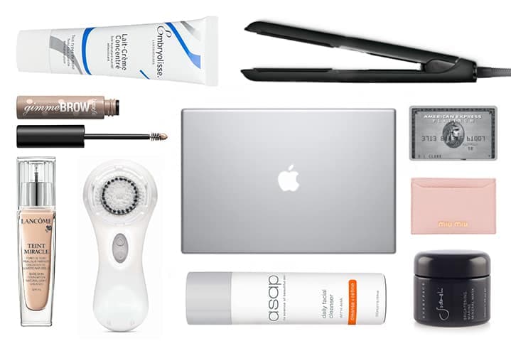 Woman browsing beauty products on laptop with cosmetics and skincare items displayed nearby
