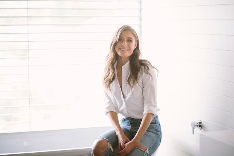 Rebecca Harding in her light-filled Melbourne home wearing minimal makeup and a neutral knit