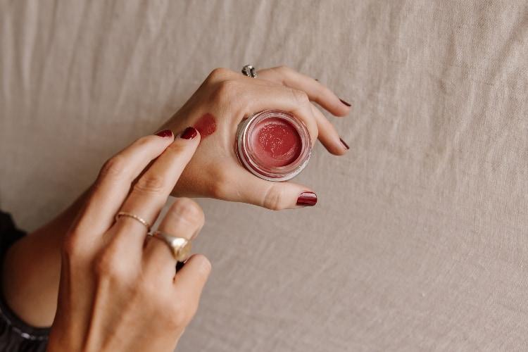 Finger swatching the No 1 de Chanel Lip and Cheek Balm from an open jar