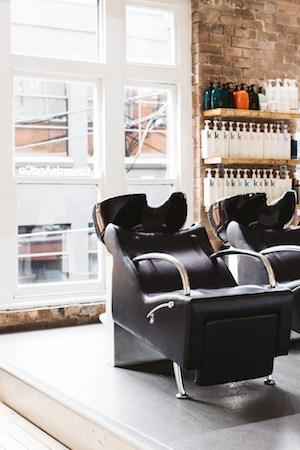Styling stations at Edwards and Co with large metal-rimmed mirrors and white tulip chairs