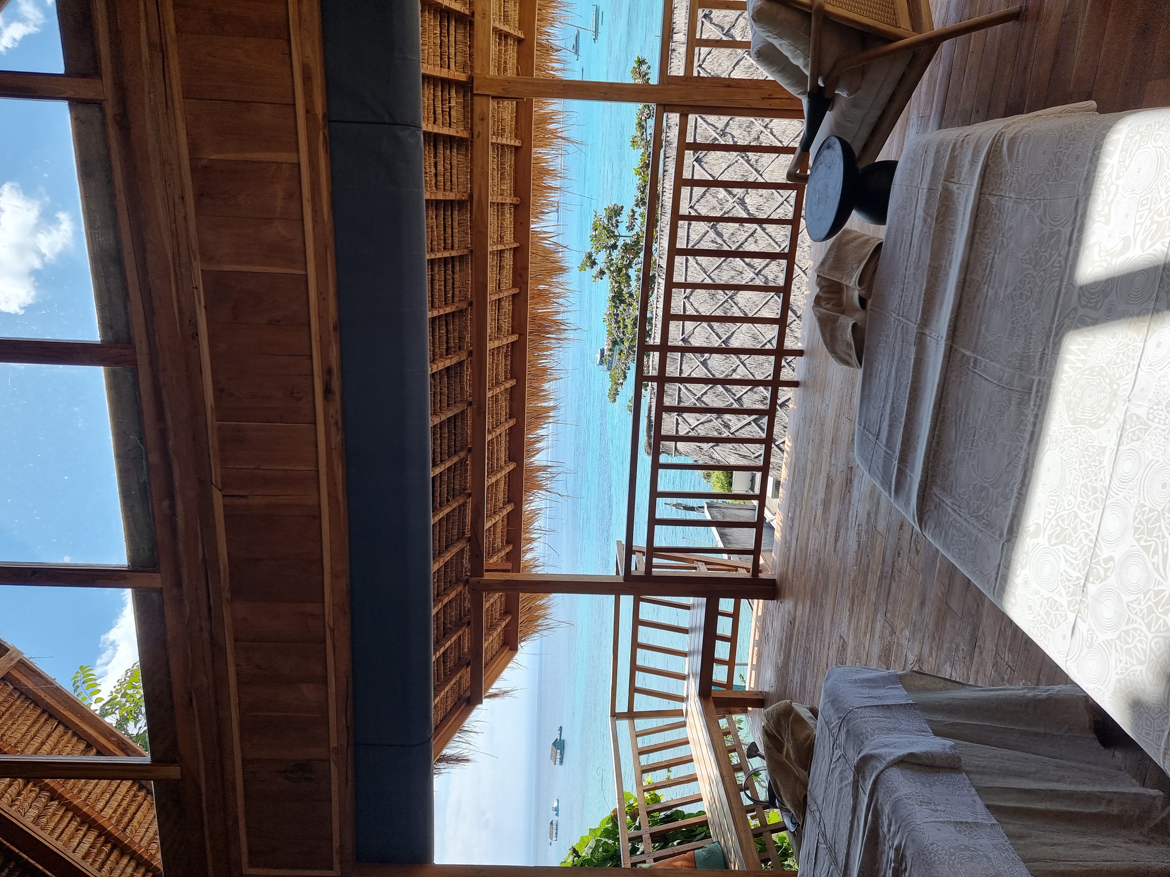 Spring Spa's clifftop terrace — open to the sea, rattan chairs, turquoise water below