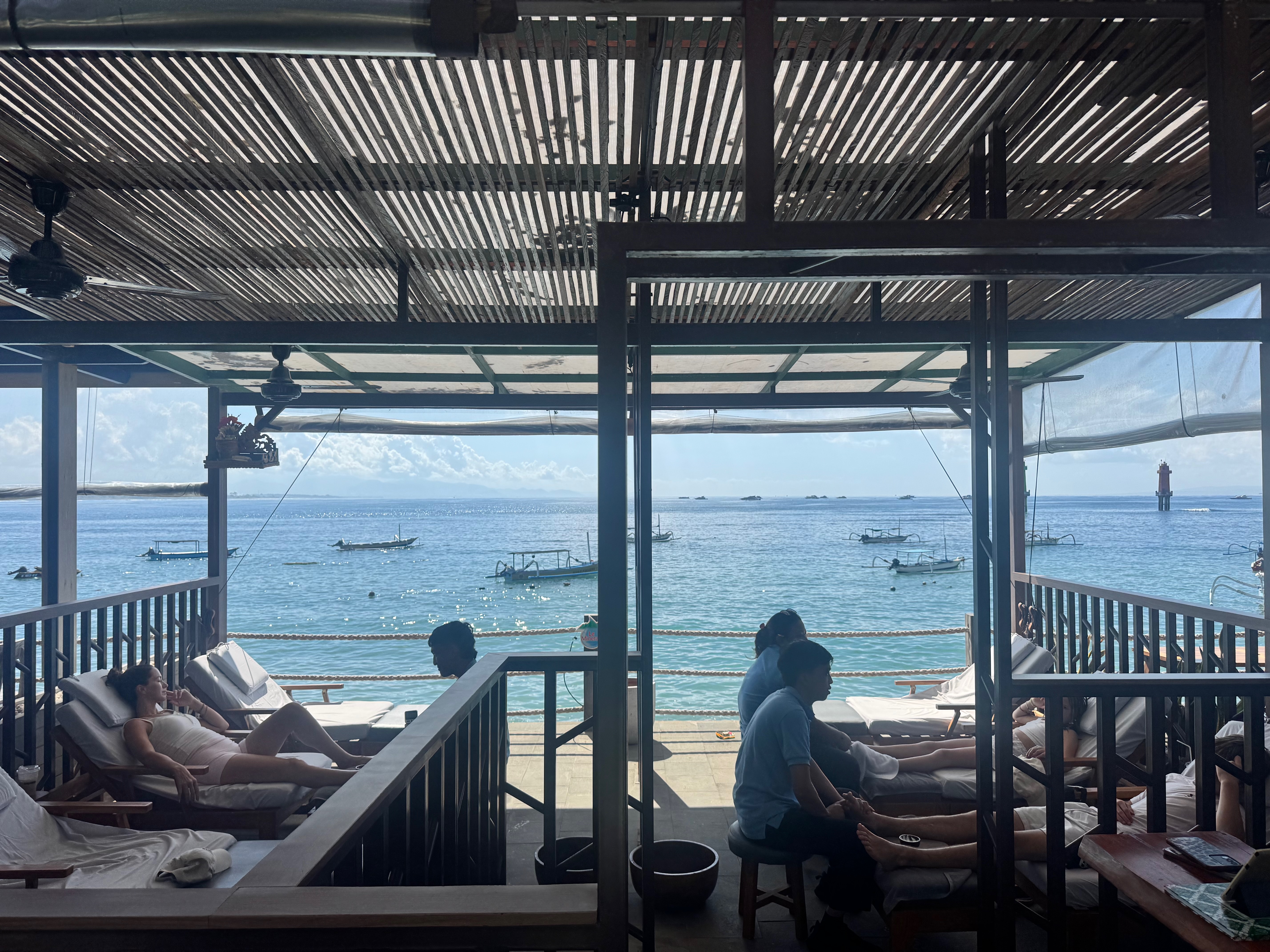 A family getting foot massages at a relaxed outdoor massage spot in Sanur, Bali