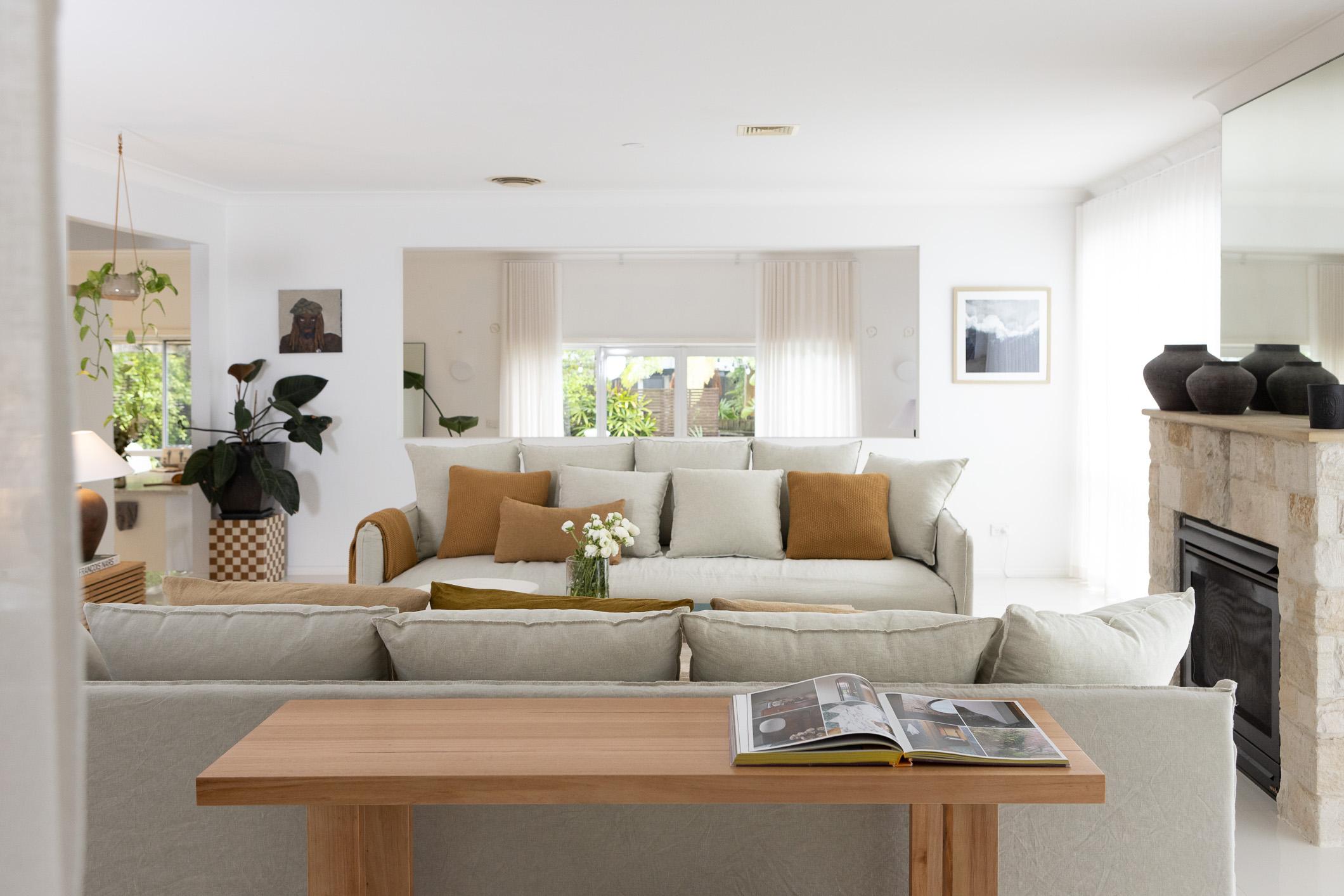 Sigourney standing beside sheer curtains in a bright, airy living space