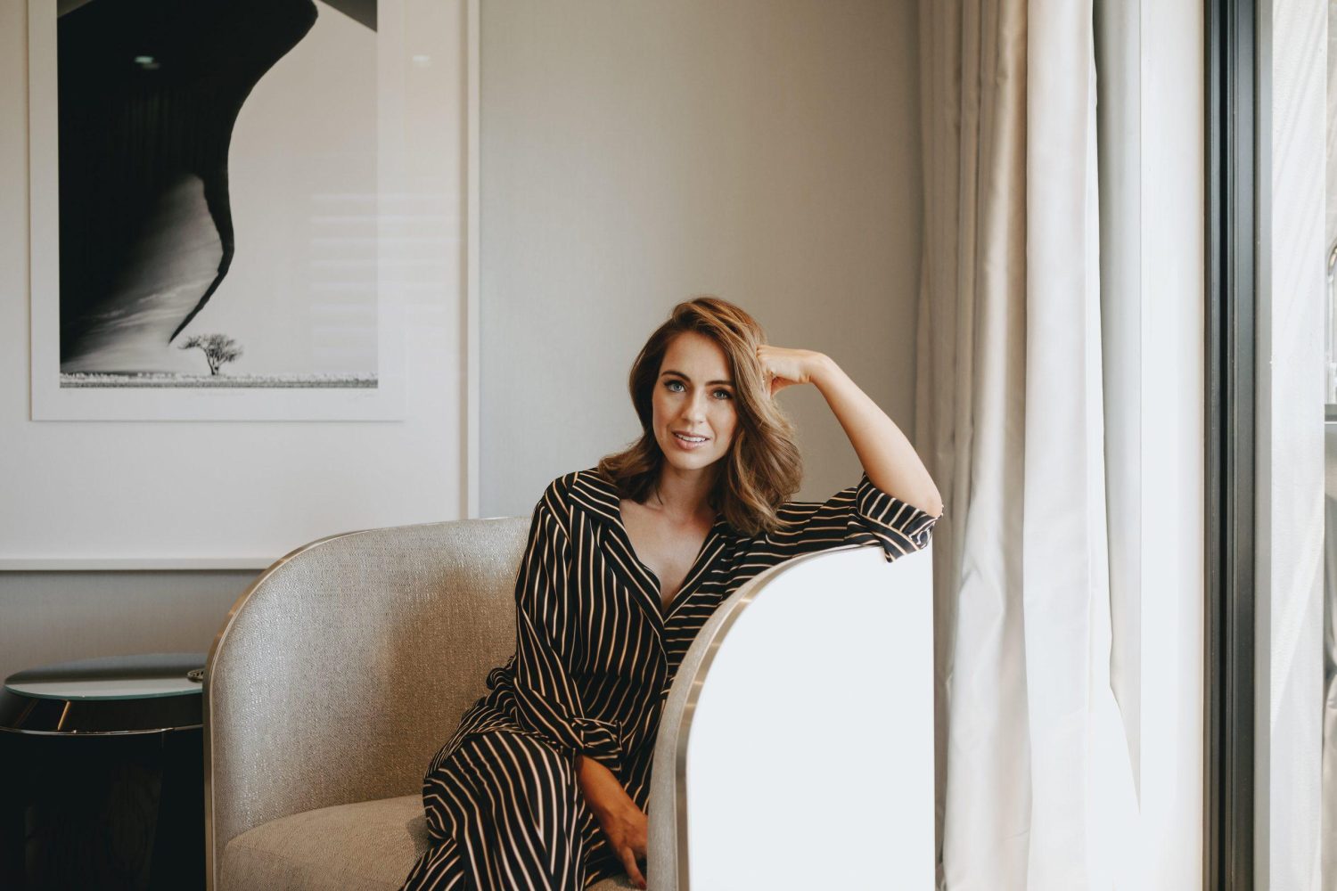 Woman in a robe seated in the All Saint Skin Clinic waiting area
