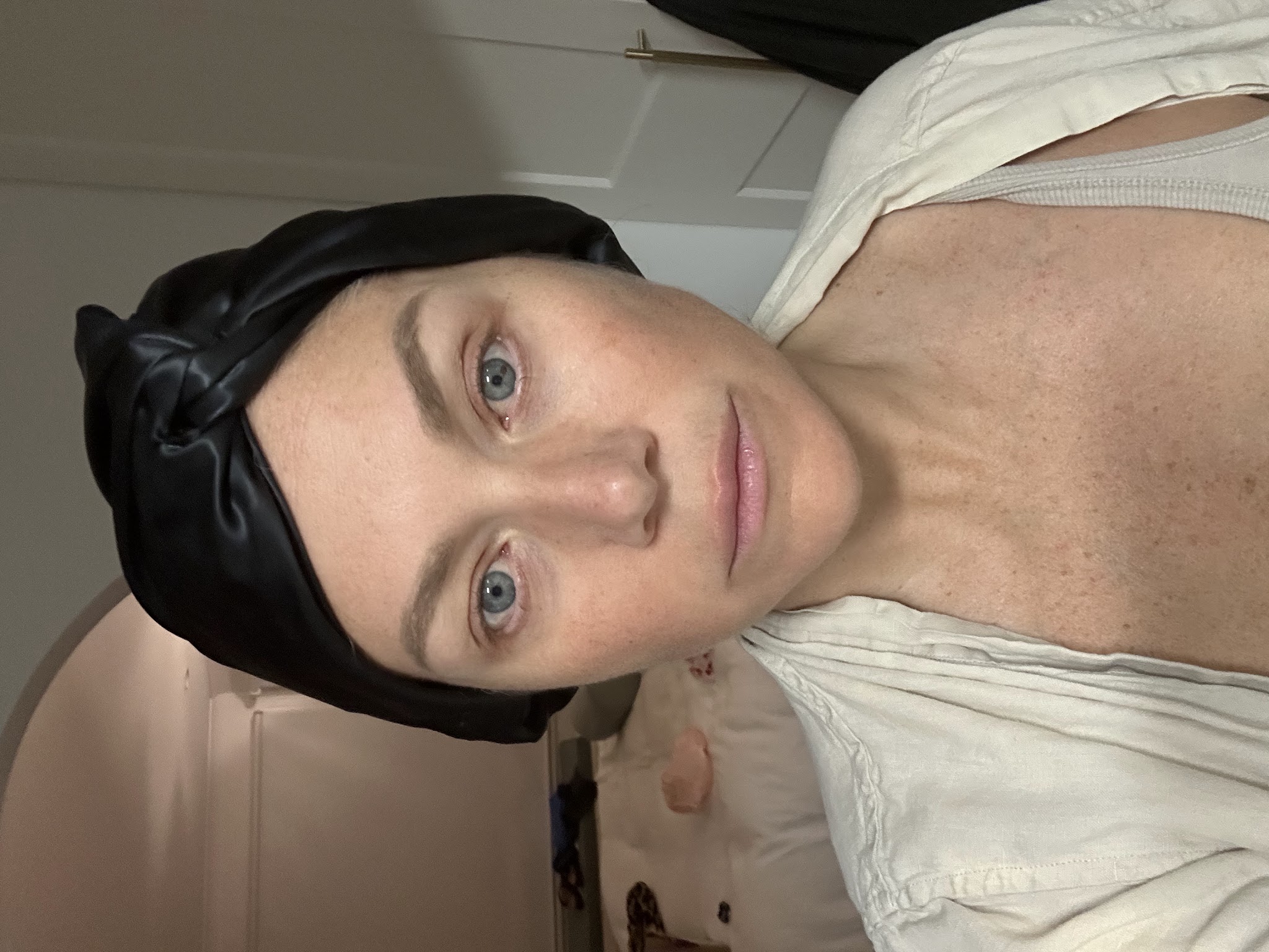 Colette in a selfie wearing a black silk headband, showing her thinning hair during treatment